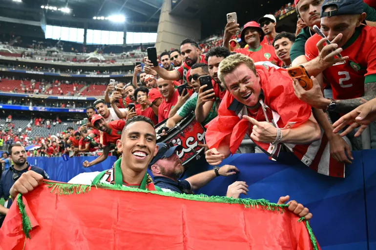L'attaquant marocain n°09 Soufiane Rahimi pose pour une photo avec des supporters alors qu'ils célèbrent la victoire des huitièmes de finale de la Coupe du monde 2026 entre le Canada et le Maroc au Houston Stadium à Houston, le 4 juillet 2026. (Photo de RONALDO SCHEMIDT / AFP)