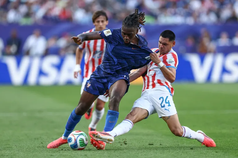 Le milieu de terrain français n°06 Manu Koné et l'attaquant paraguayen n°24 Gustavo Caballero se battent pour le ballon lors des huitièmes de finale de la Coupe du monde 2026 entre le Paraguay et la France au stade de Philadelphie, à Philadelphie, le 4 juillet 2026. (Photo de CHARLY TRIBALLEAU / AFP)