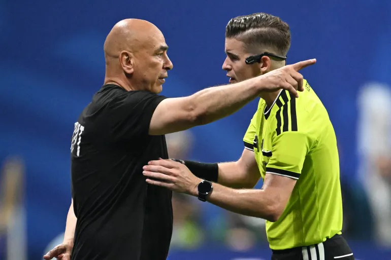L'entraîneur-chef égyptien Hossam Hassan s'entretient avec l'arbitre français François Letexier lors des huitièmes de finale de la Coupe du monde 2026 entre l'Argentine et l'Égypte au stade d'Atlanta à Atlanta, le 7 juillet 2026. (Photo de ROBERTO SCHMIDT / AFP)