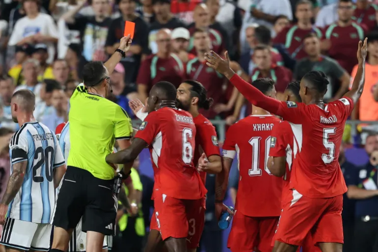 L'arbitre portugais Joao Pinheiro tire un carton rouge, après un deuxième carton jaune délivré à l'attaquant suisse n°07 Breel Embolo (invisible) lors du quart de finale de la Coupe du monde de football 2026 entre l'Argentine et la Suisse au Kansas City Stadium de Kansas City, le 11 juillet 2026. (Photo de Thomas COEX / AFP)