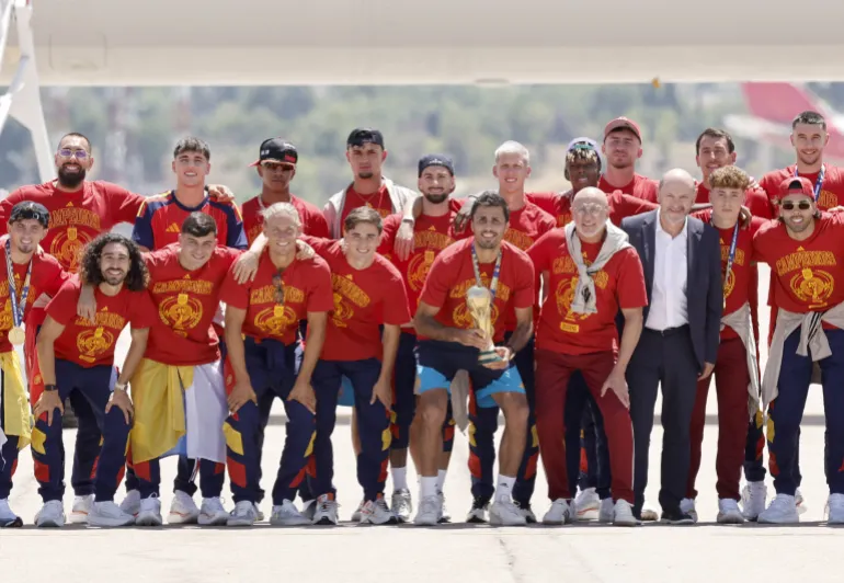 L'équipe espagnole pose avec son trophée sur le tarmac à son arrivée des États-Unis après avoir remporté la Coupe du monde 2026, à l'aéroport de Madrid Barajas, le 20 juillet 2026. Les vainqueurs espagnols de la Coupe du monde reviennent chez eux pour un accueil de héros à Madrid, où un million de fans devraient les saluer après une nuit de célébrations bruyantes à travers le pays. (Photo par Oscar DEL POZO / AFP)