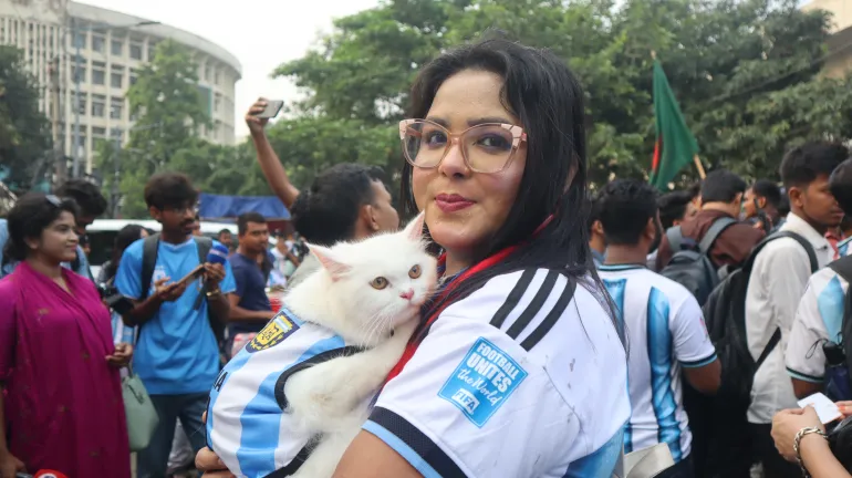 La supporter argentine Zubaida Islam Jerin avec son chat de compagnie, nommé Messi – également vêtu d'un maillot argentin [Masum Billah/ Al Jazeera]
