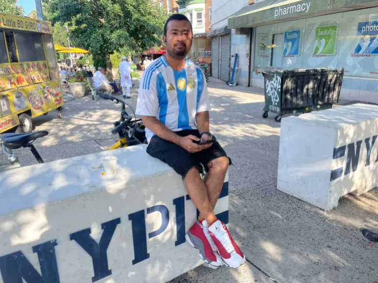 Le fan argentin Sajid Bhuyan est assis sur une barrière du NYPD à Kensington