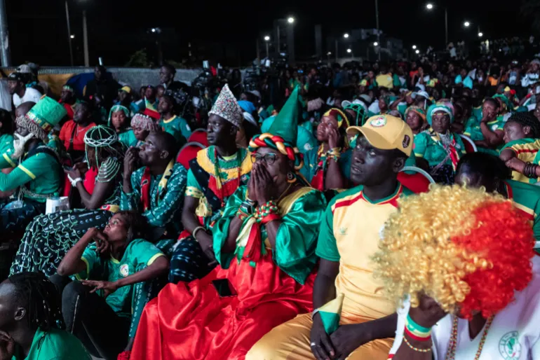 Les supporters sénégalais réagissent après la défaite de leur équipe en huitièmes de finale de la Coupe du monde 2026 contre la Belgique alors qu'ils regardent le match dans la Fan Zone de la FIFA, place de l'Obélisque à Dakar, le 1er juillet 2026.