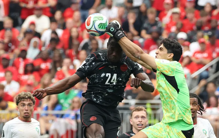 TOPSHOT - Le gardien de but marocain #01 Yassine Bounou dégage le ballon devant l'attaquant canadien #24 Promise David lors des huitièmes de finale de la Coupe du monde 2026 entre le Canada et le Maroc au Houston Stadium à Houston, le 4 juillet 2026.