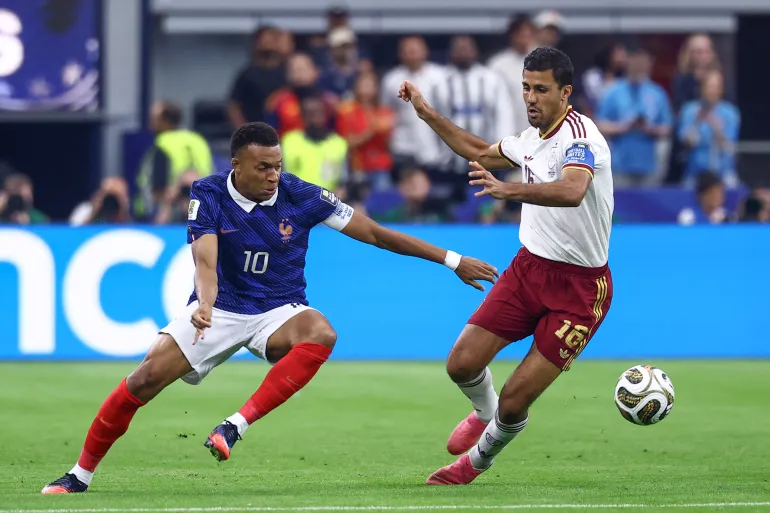 L'attaquant français n°10 Kylian Mbappe et le milieu de terrain espagnol n°16 Rodri se battent pour le ballon lors de la demi-finale de la Coupe du monde de football 2026 entre la France et l'Espagne au stade de Dallas à Arlington le 14 juillet 2026.
