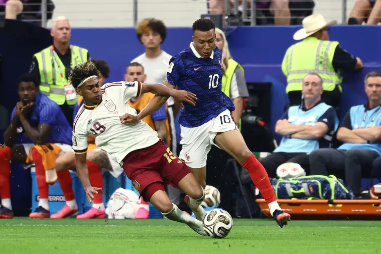 L'attaquant espagnol n°19 Lamine Yamal commet une faute sur l'attaquant français n°10 Kylian Mbappe lors de la demi-finale de la Coupe du monde de football 2026 entre la France et l'Espagne au stade de Dallas à Arlington le 14 juillet 2026.