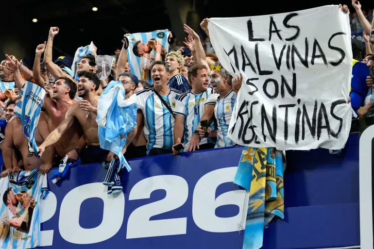 Les supporters argentins tiennent une banderole avec les mots "Les Malvinas sont argentines"faisant référence aux îles Falkland, à la fin de la demi-finale de la Coupe du monde de football entre l'Angleterre et l'Argentine à Atlanta, le mercredi 15 juillet 2026. (AP Photo/Rebecca Blackwell)