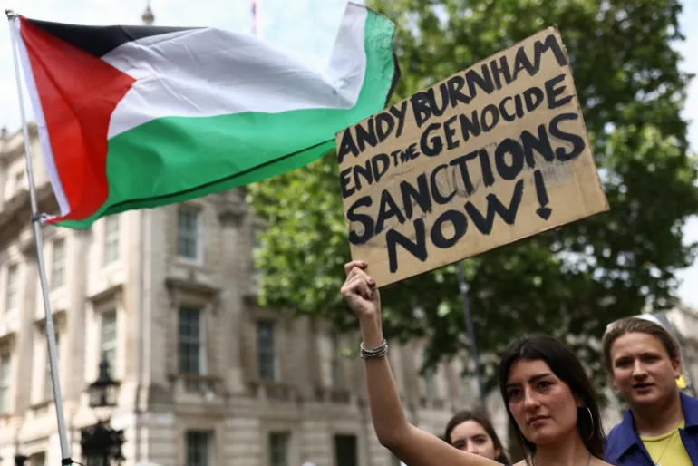 Une femme tient une pancarte à l'extérieur de Downing Street lors d'une "Marche nationale pour la Palestine" appelant le prochain Premier ministre britannique, Andy Burnham, à défendre le peuple palestinien, à Londres, en Grande-Bretagne, le 18 juillet 2026. REUTERS/Jack Taylor